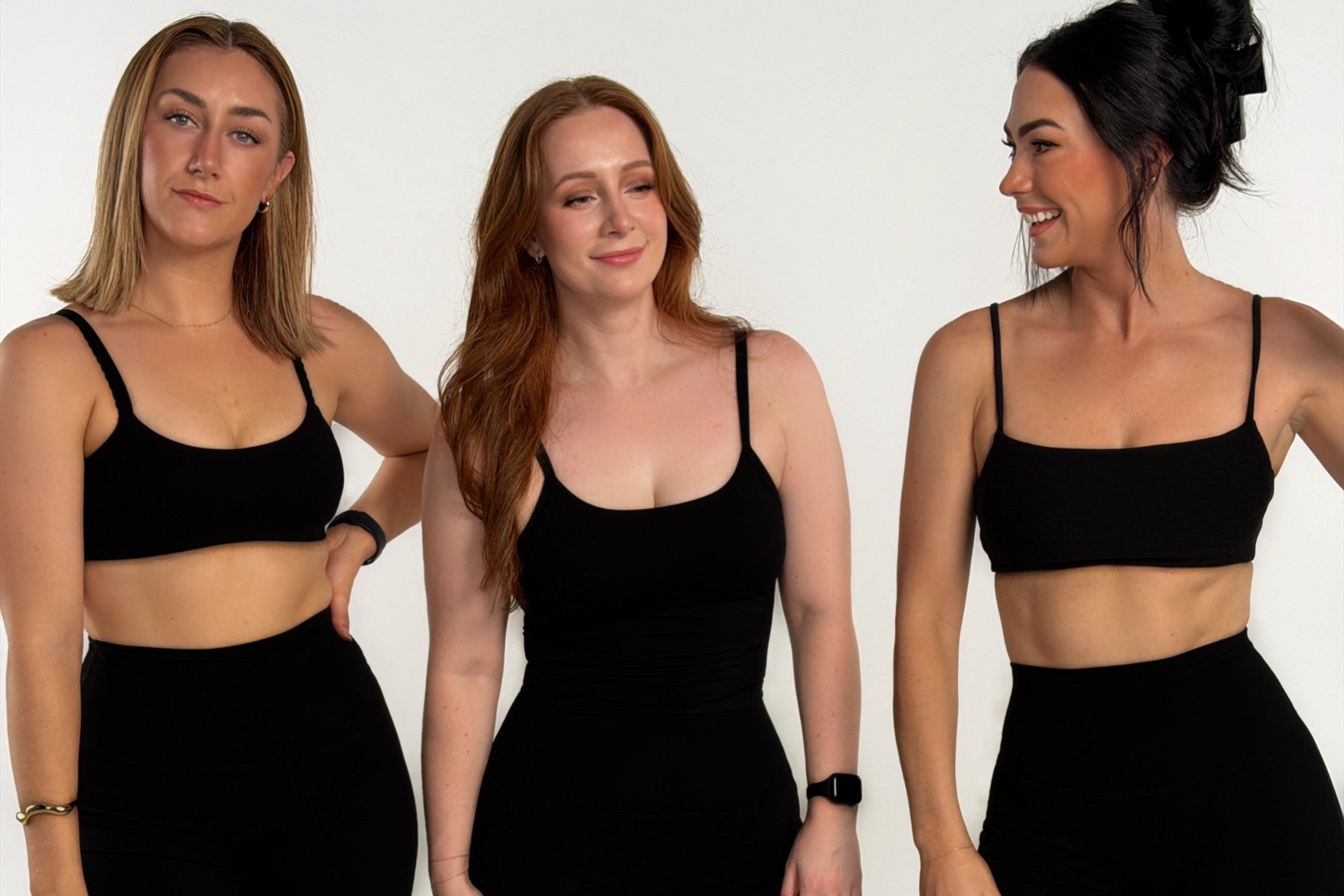 Three women wearing black athletic wear posing against a white background