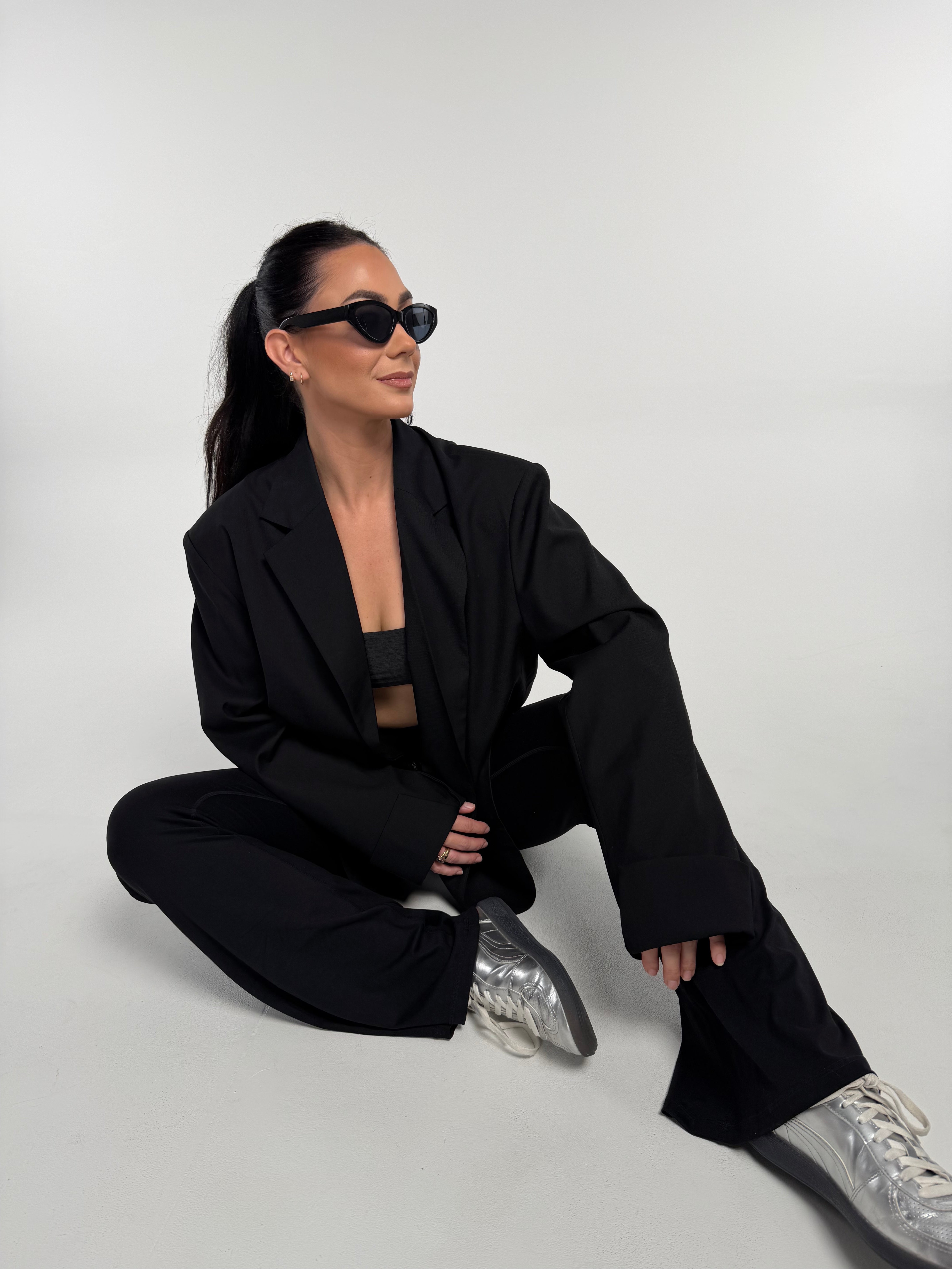 Neen Seated wearing the Noa Rae Reign Blazer and the Noa with a flare tight.