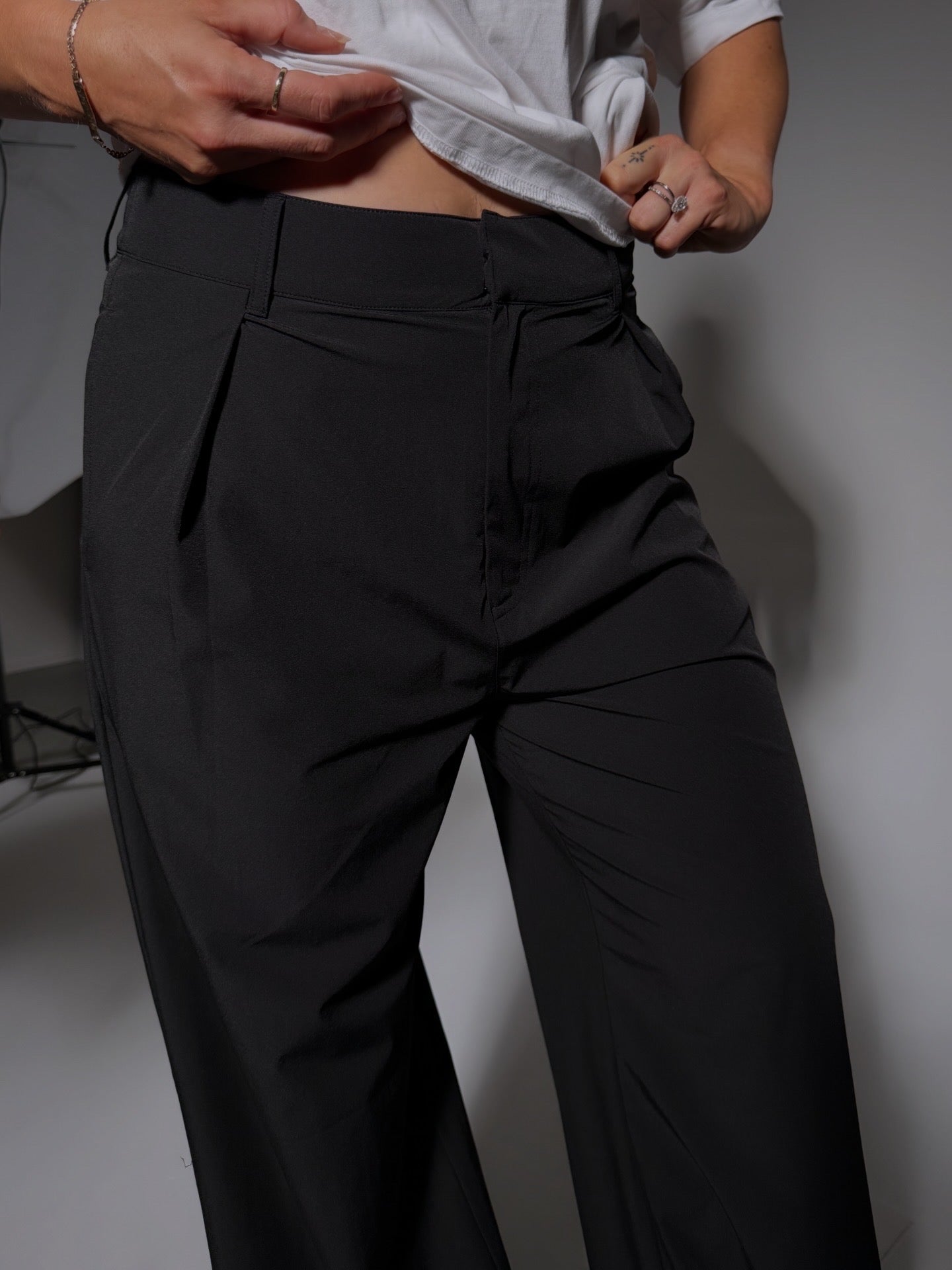 Person wearing black drew pants with a plain background