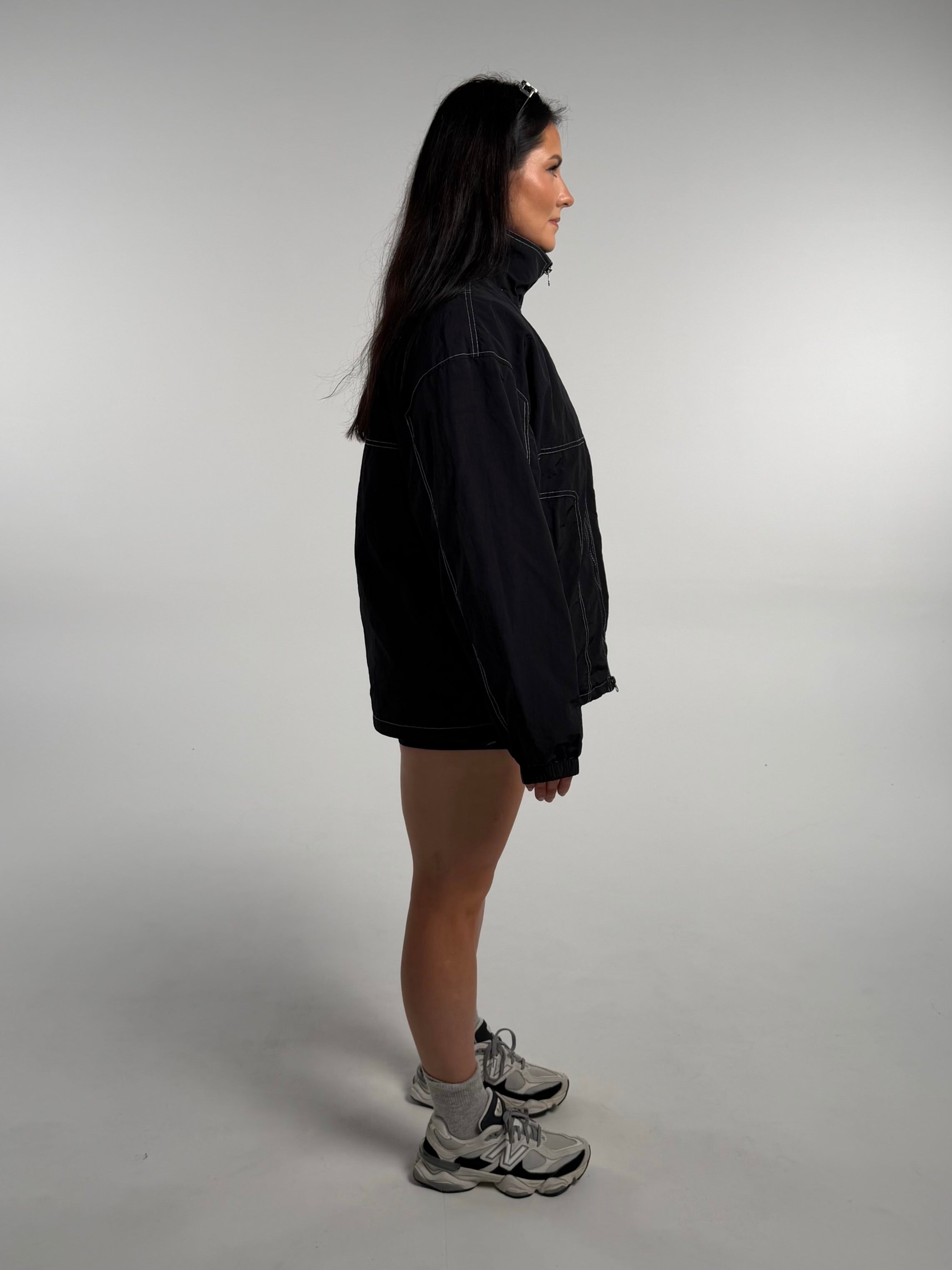 Active girl wearing a black and white windbreaker. 