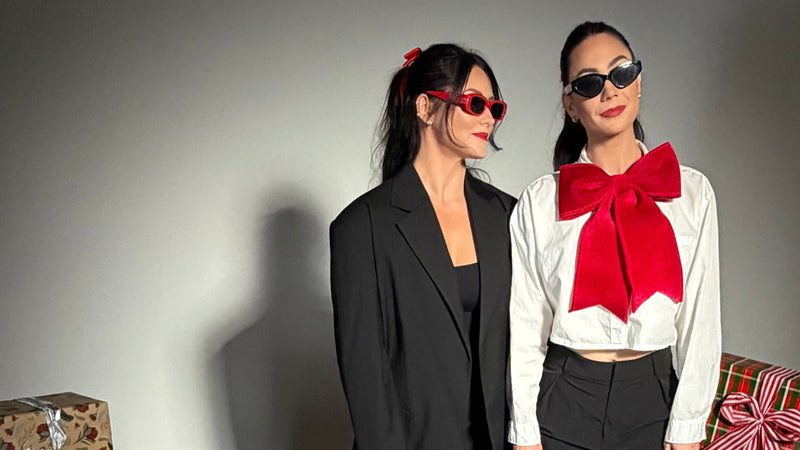 Two besties celebrating on a gray floor with Christmas presents and cards around them.